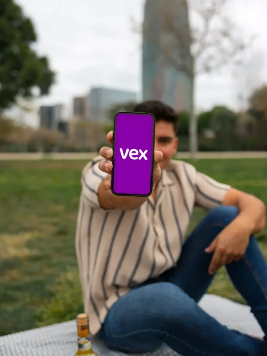 Usuario mostrando la app Vex Wallet para aceptar pagos y recibir remesas desde USA